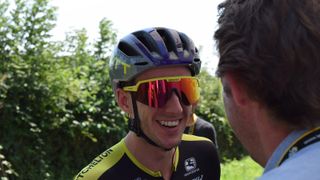 Adam Yates shares a joke with directeur sportif Matt White ahead of the stage