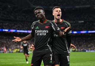 Bukayo Saka celebrates with Gabriel Martinelli after scoring for Arsenal against Real Madrid in the Champions League at the Santiago Bernabeu in April 2025.