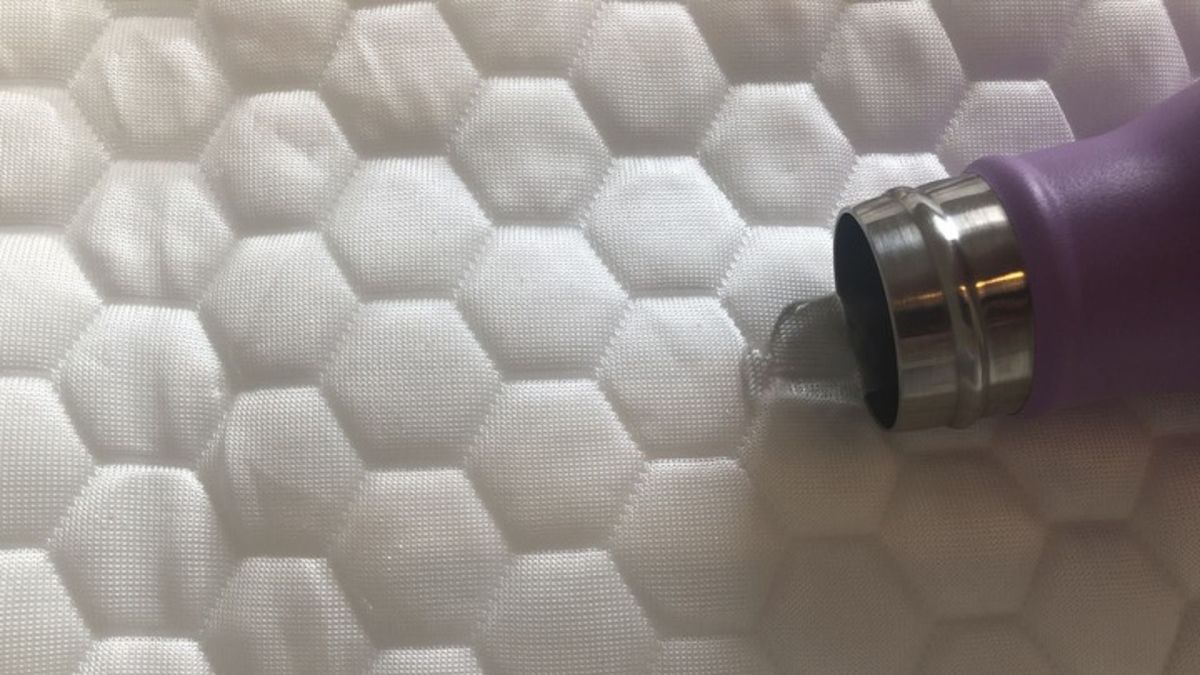 A water bottle spills water on the Luxury Cooling Mattress Protector