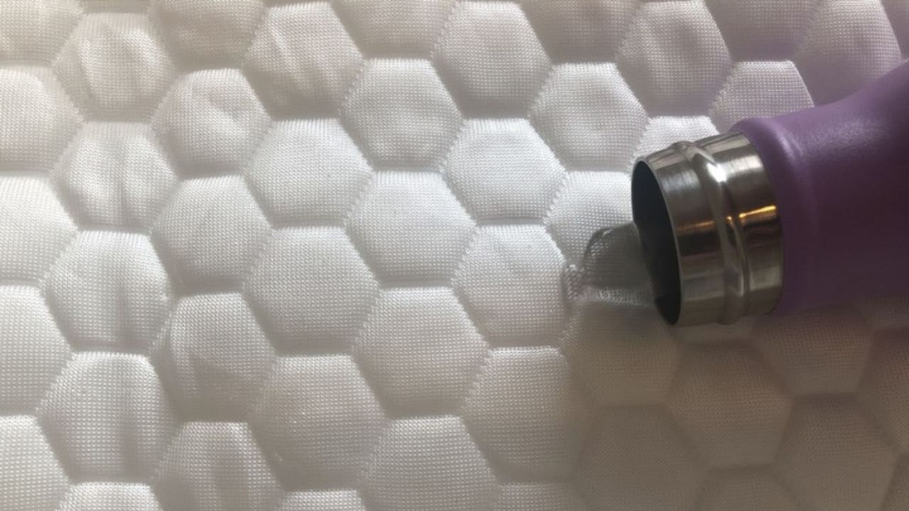 A water bottle spills water on the Luxury Cooling Mattress Protector