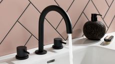 black tap with pink tiles