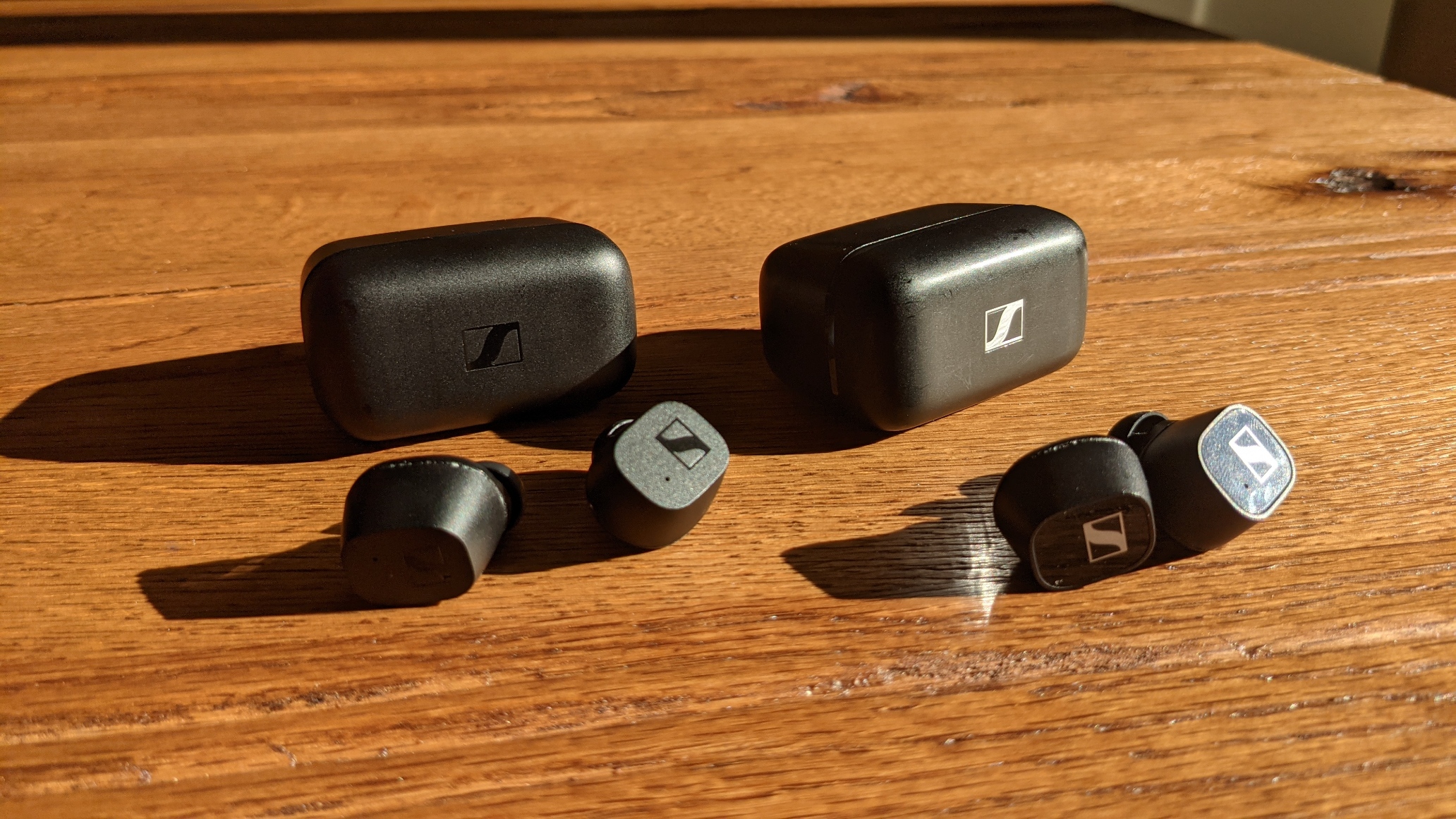 Sennheiser CX True Wireless links und Sennheiser CX 400BT mit Cases nebeneinander auf einem Tisch