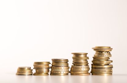 Five stacks of golden coins growing on white background