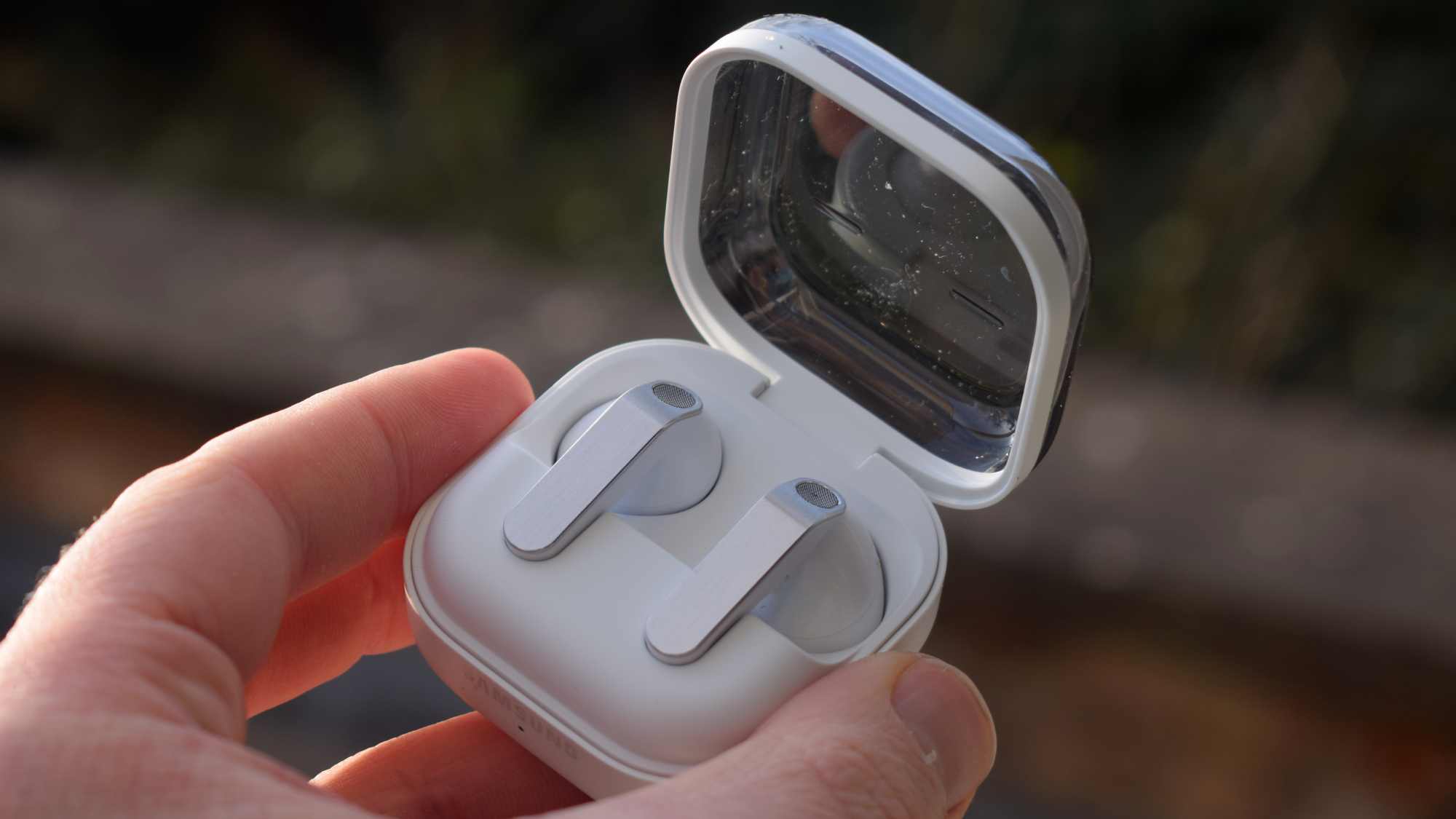 The Samsung Galaxy Buds 4 case in a man's hand.