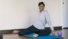 Smiling woman holds 90-90 stretch