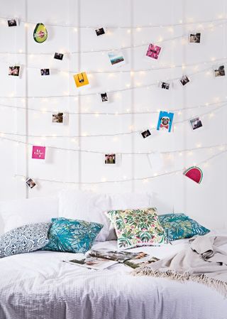 Fairy lights gallery wall with photographs in contemporary young bedroom