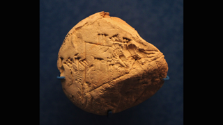 Small round cuneiform tablet with writing and a triangle