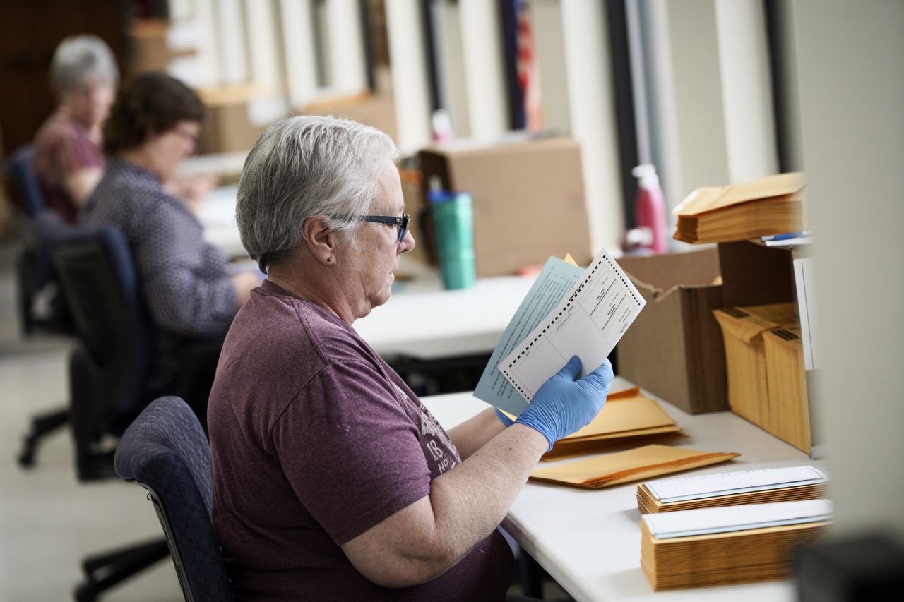 A person stuffs mail-in ballots in Nebraska.