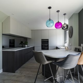 Grey and white kitchen with colourful pendant lights