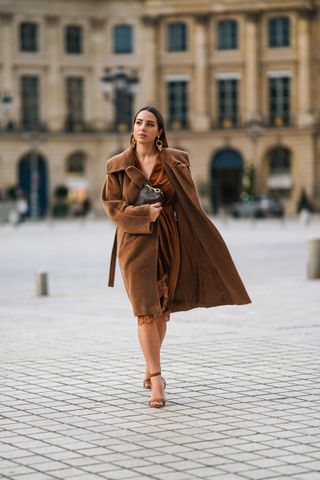 woman wearing brown dress, brown coat, and heels