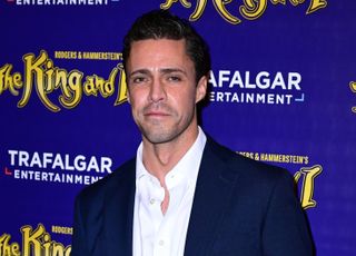 An image of Olly Rix smiling on a red carpet event for The King and I in London.