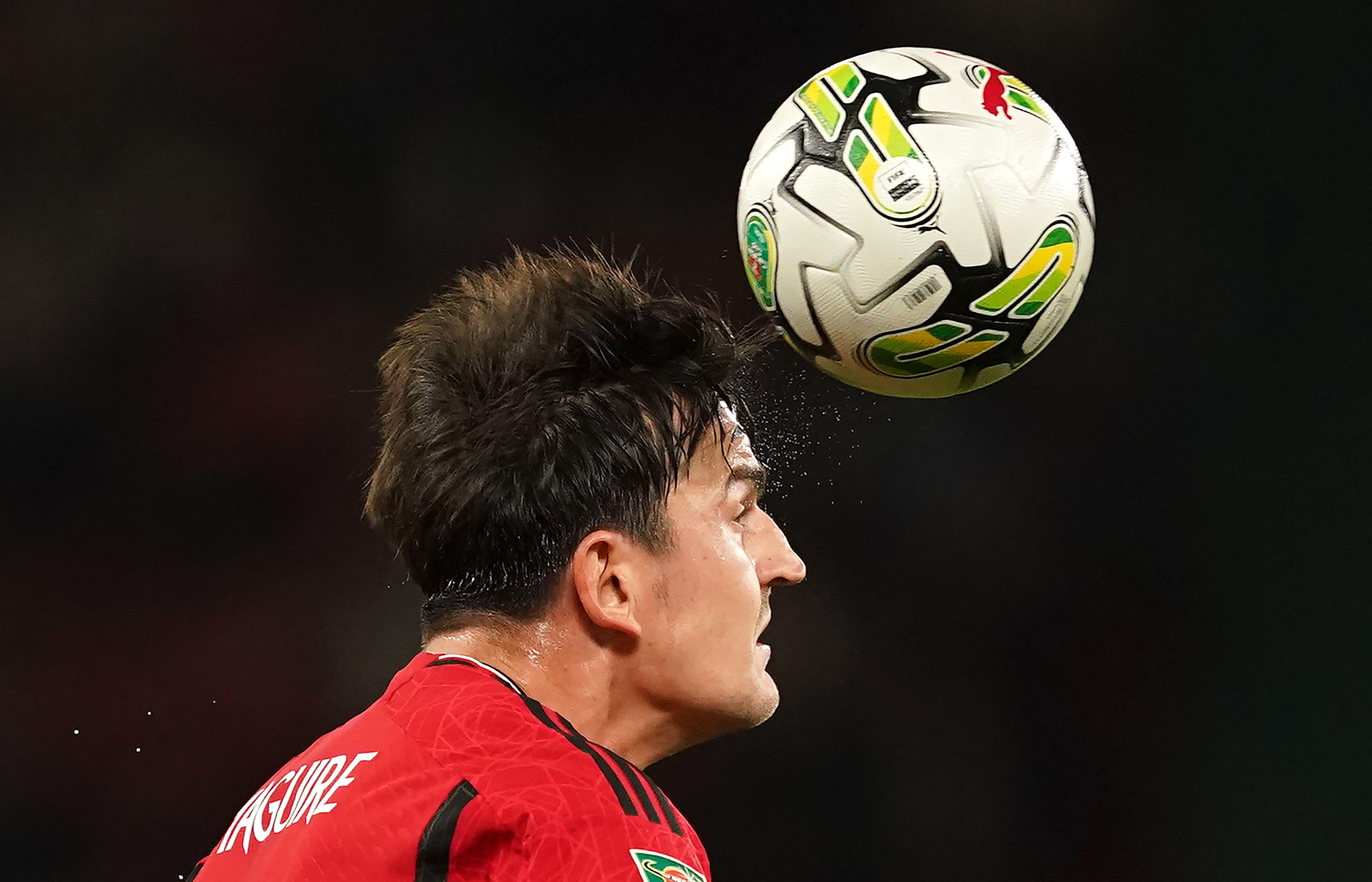 Harry Maguire heads the ball while playing for Manchester United, 2023