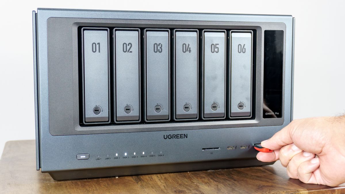 A person inserting a flash drive into one of the front ports on the Ugreen iDX6011 Pro