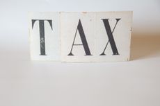 the word tax on an ivory background