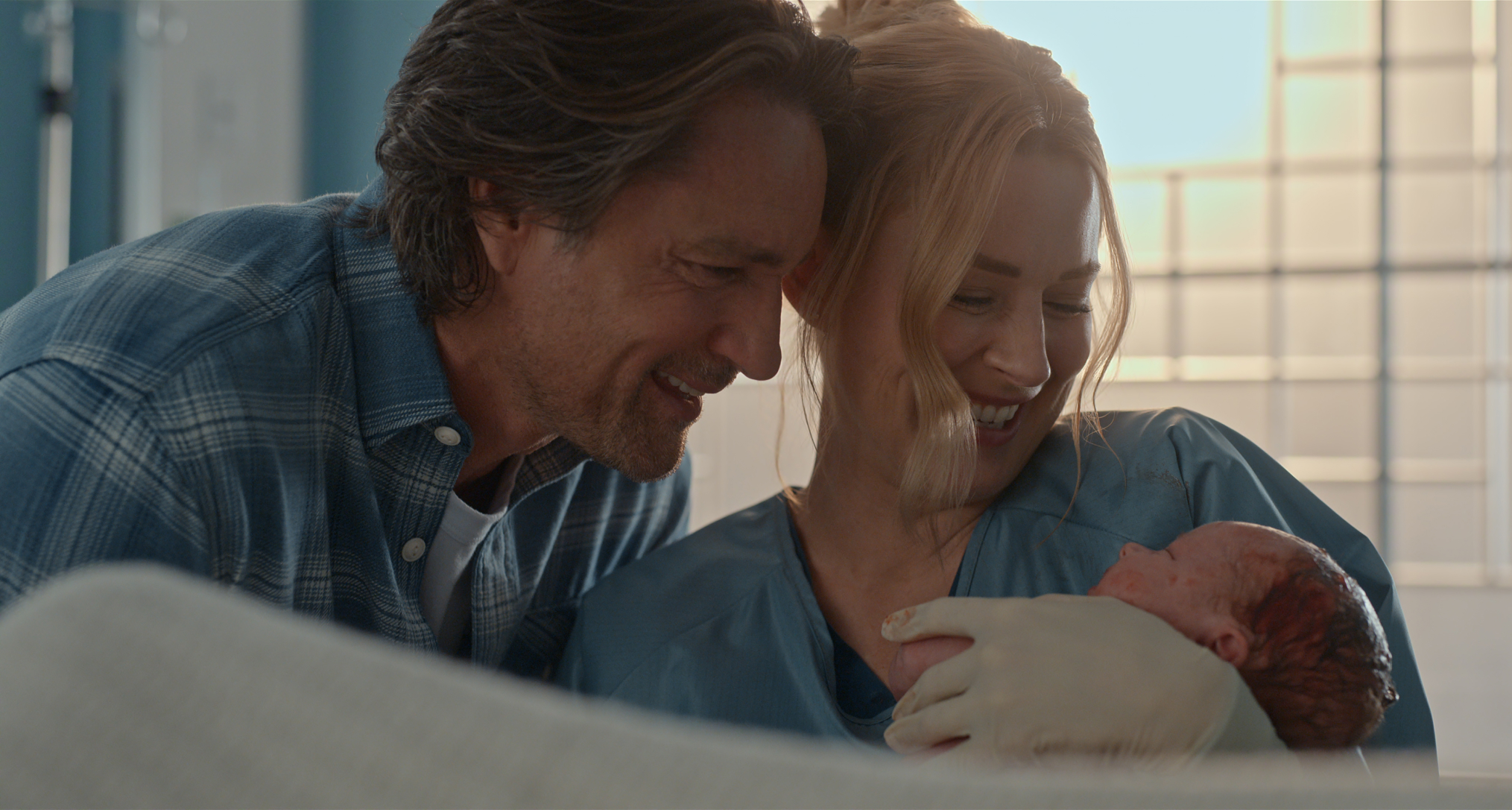 jack and mel smile while holding their newborn son in a still from virgin river season 7