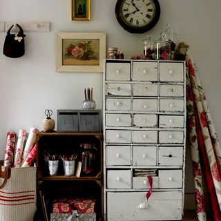 craft room with old white storage unit and white wall