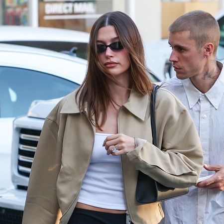 Hailey Bieber wearing a tan bomber jacket with Justin Bieber