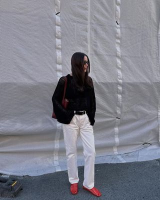 @annabelrosendahl wearing red flats with white jeans and black jumper