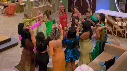 A group of women stand in a circle and toast their golden wine glasses in the &#039;Love is Blind&#039; women&#039;s lounge, in episode 701 of &#039;Love is Blind.&#039;