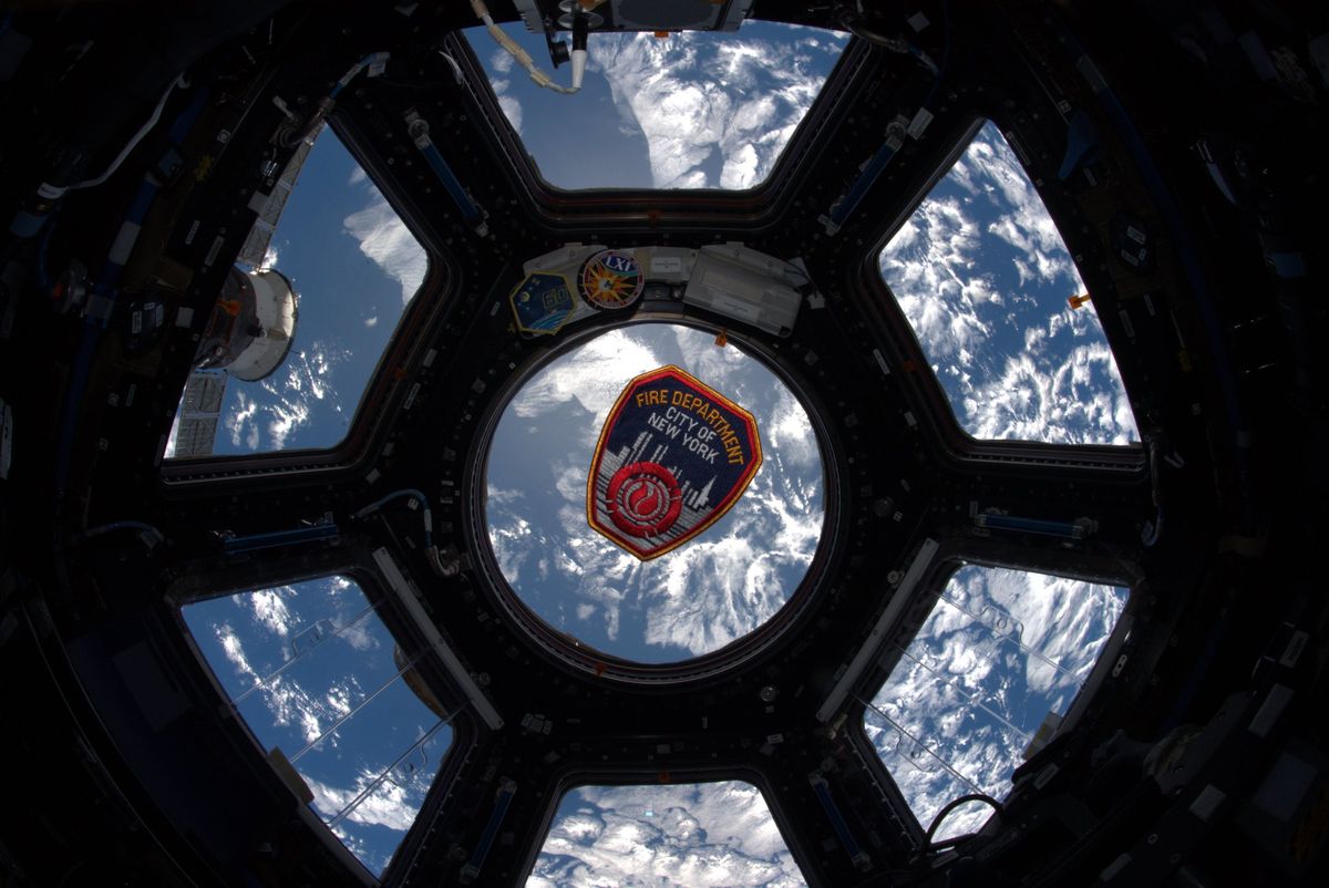 A New York City Fire Department patch floats in the Cupola window of the International Space Station on the 18th anniversary of the 9/11 terror attacks. 