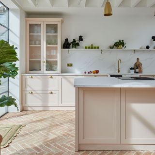 Pink shaker kitchen with herringbone terracotta tiles and white marble splashback