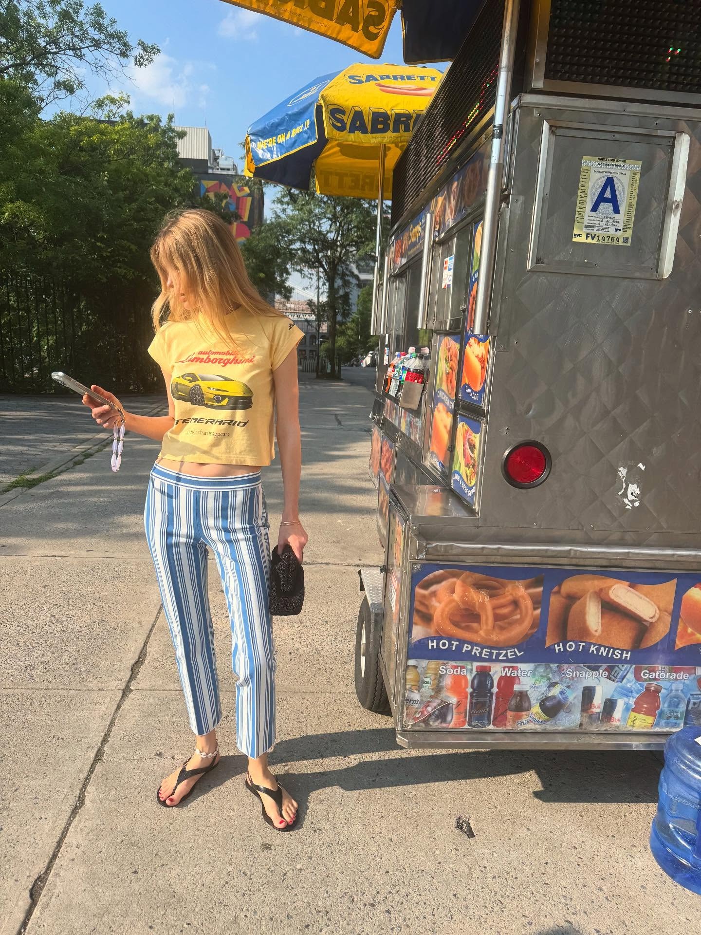 Woman in graphic tee and striped pants.