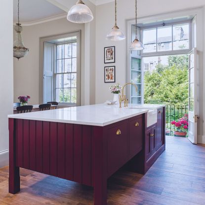 Harvey Jones traditional kitchen with dark red island and light pink cabinetry