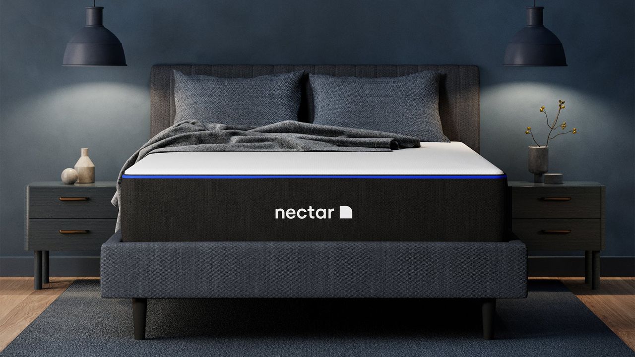 The Nectar Memory Foam Mattress UK on a bed frame in a bedroom, a pillow and blanket on top