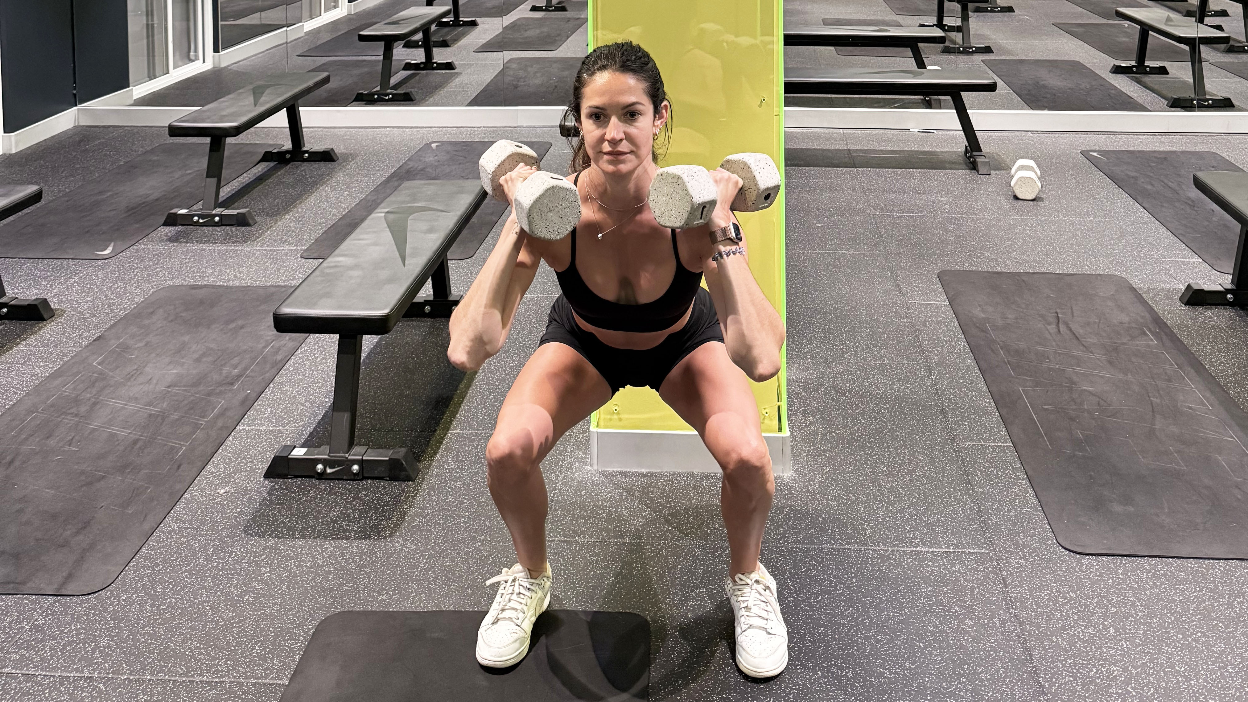A photo of fitness writer Lucy Gornol is doing a dumbbell thruster 