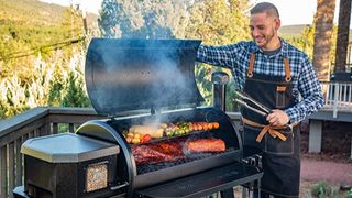 A man using a Pit Boss grill to cook on his porch