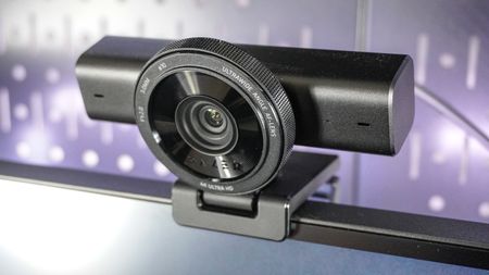 The Razer Kiyo V2 webcam perched on top of a monitor with pegboard behind it