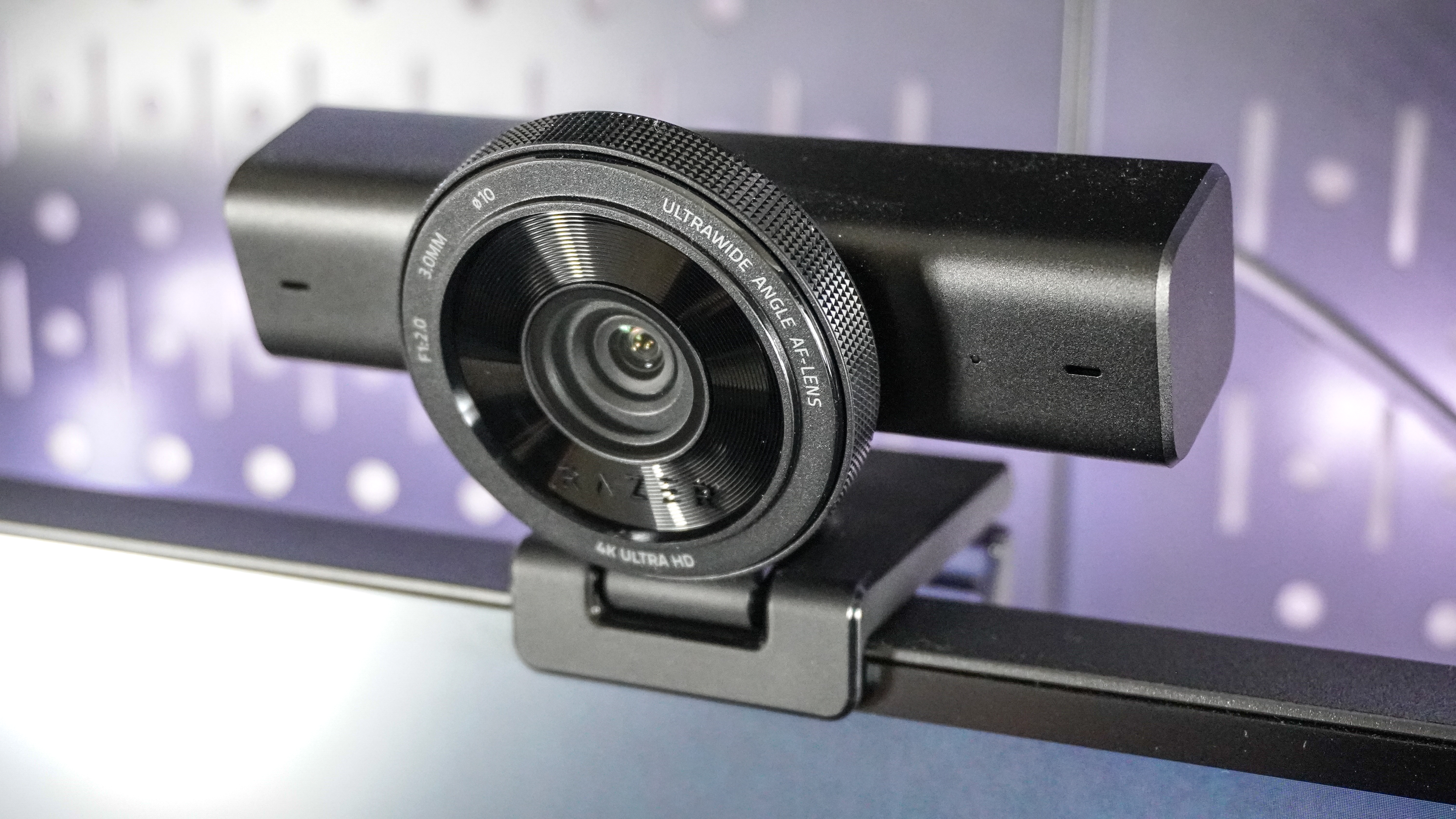 The Razer Kiyo V2 webcam perched on top of a monitor with pegboard behind it