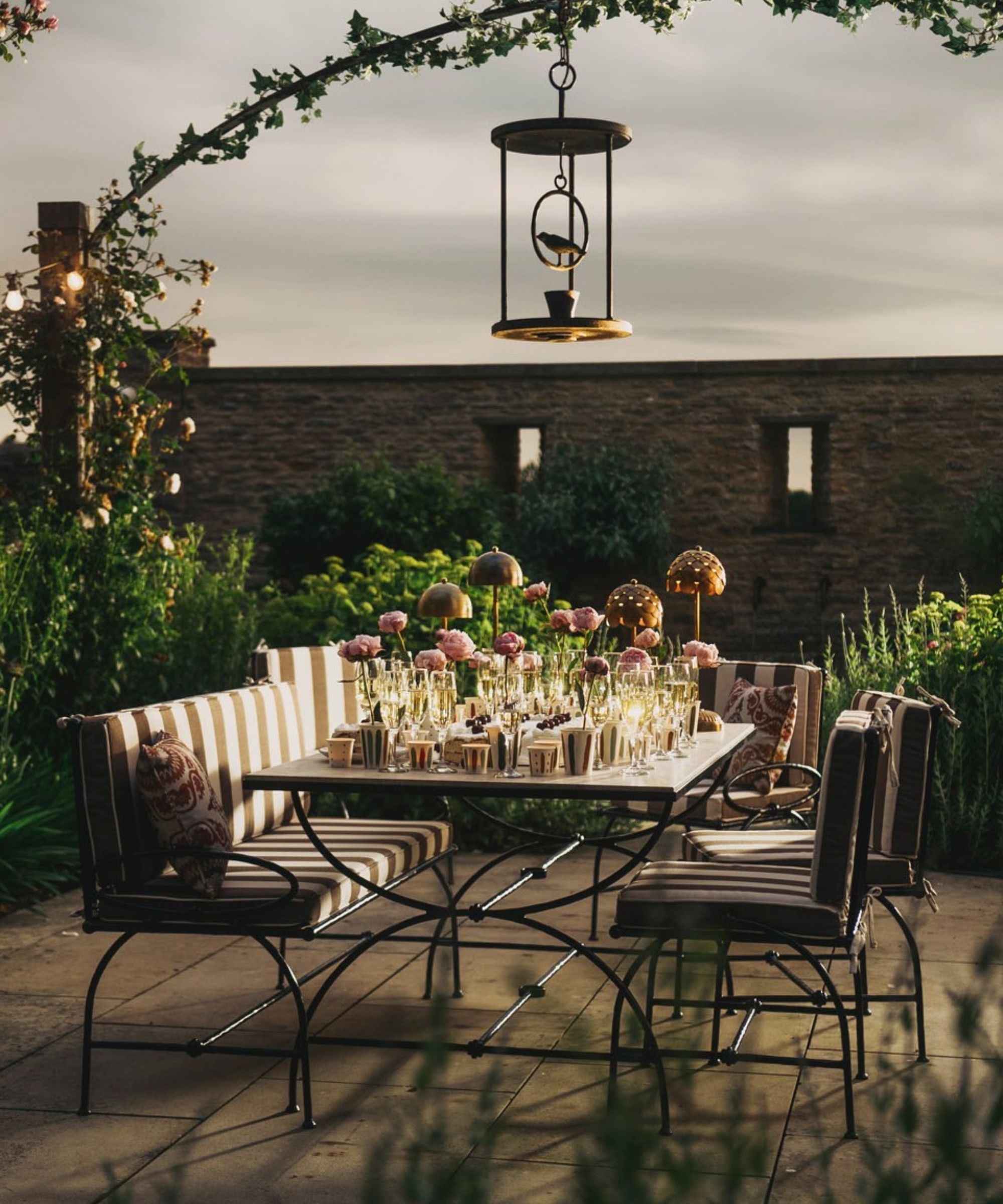 Patio with iron garden furniture and seating with striped upholstery