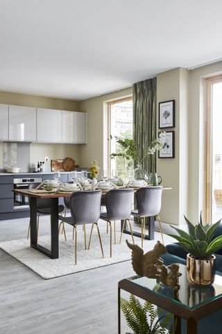 A transitional style kitchen with green curtains and a wooden dining table