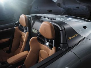Porsche Speedster shows brown leather seats with the roof pulled down.