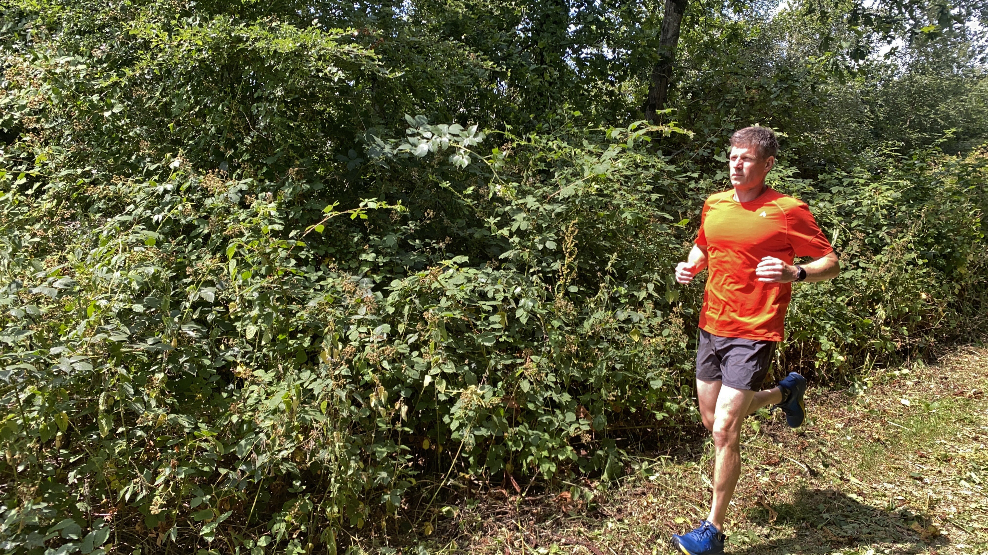 Man running trails wearing the Topo Athletic MTN Racer 4 shoes