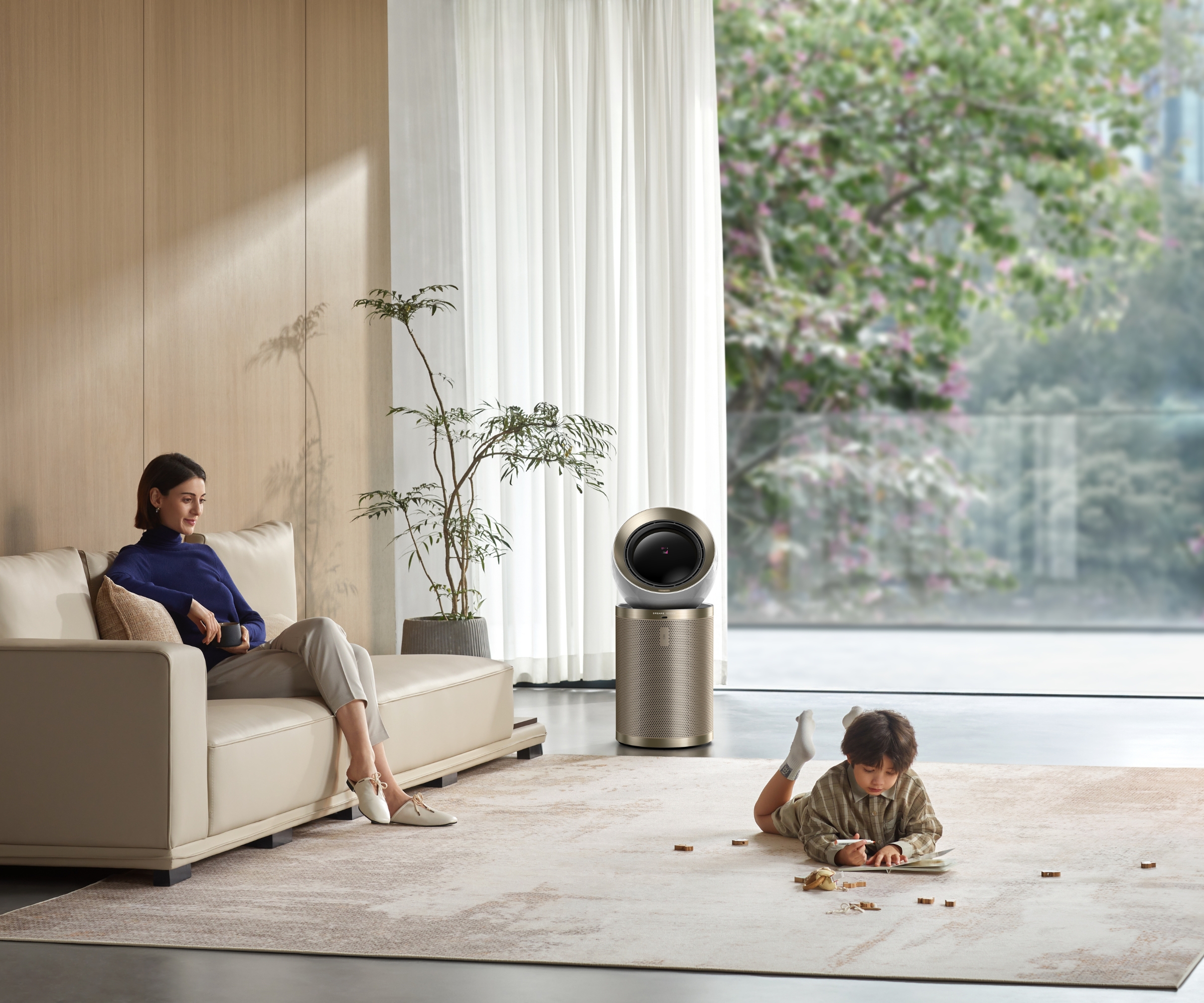 Dreame AirPursue PM20 air purifier in middle of bright, minimalist living room where mother and child are spending time, pictured in front of large window revealing greenery.