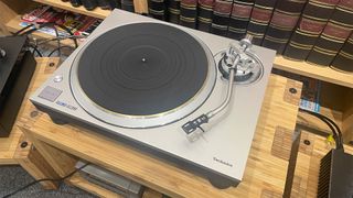 Technics SL-1300G turntable on wooden hi-fi rack in front of bookcase