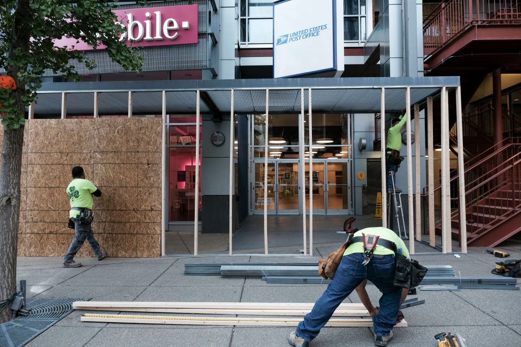 Workers board up businesses in Louisville.