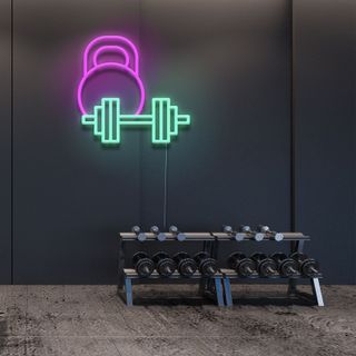 black home gym with a pink and blue neon wall picture of weights