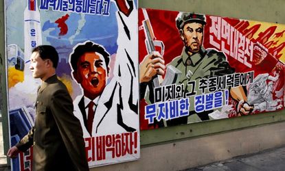 A man walks past propaganda posters in Pyongyang, North Korea on March 26.
