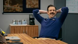 Jason Sudeikis sits with his arms behind his back in Ted Lasso season 3.