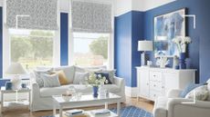 Blue living room with white sofa and white wooden furniture