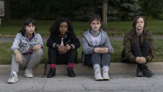 Tiffany, Erin, Mac and KJ sitting on sidewalk in Paper Girls