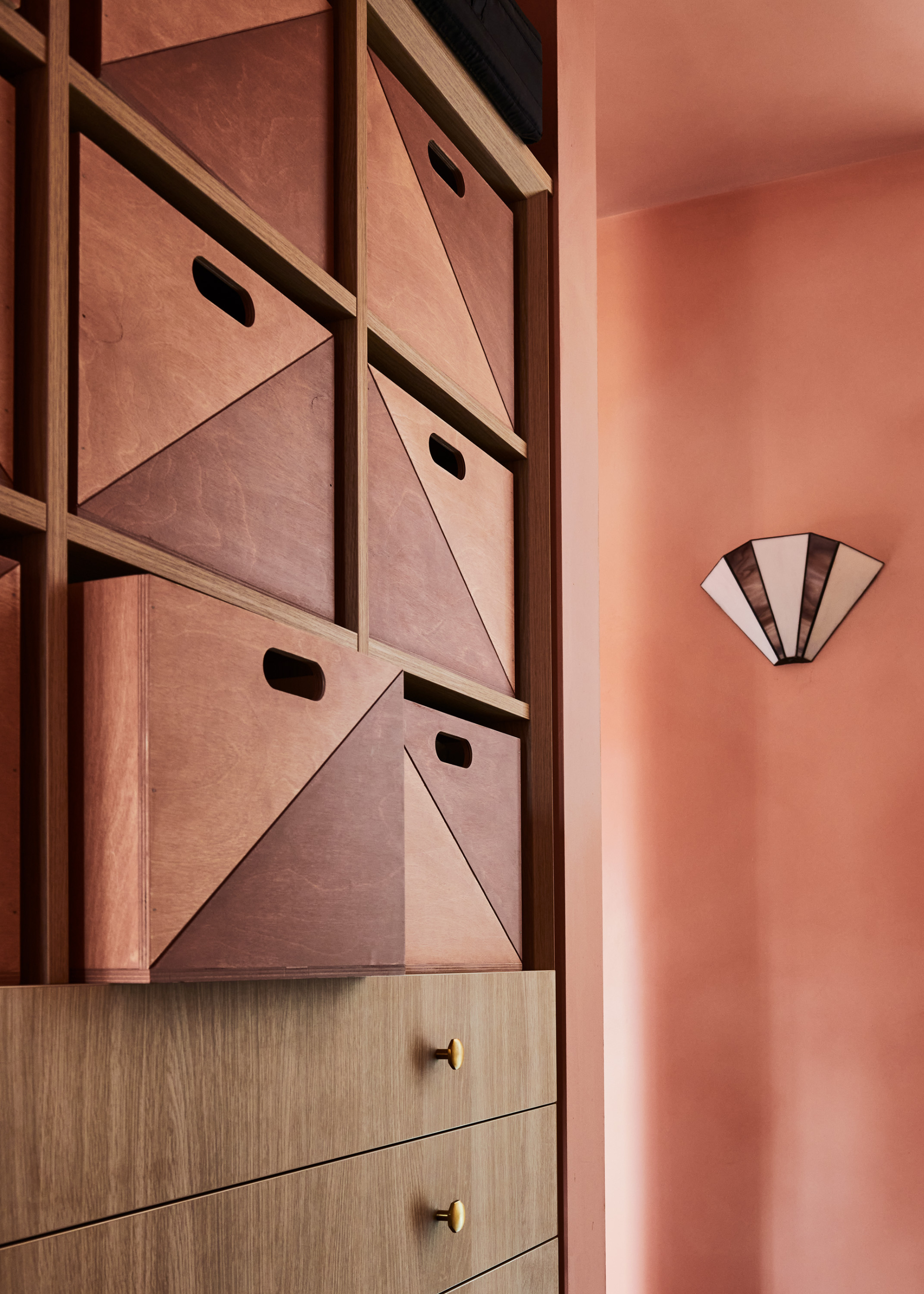 An earthy pink room with dual-toned wooden storage boxes