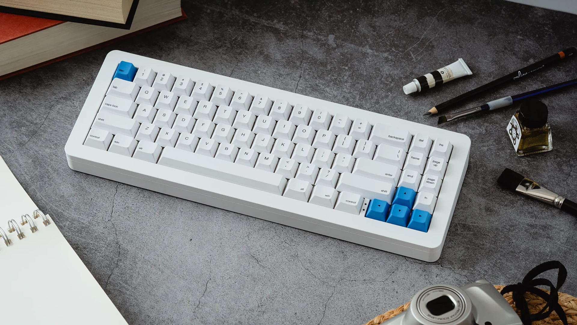 The WhiteFox Eclipse Mechanical Keyboard on a desktop with paint and pencils nearby.