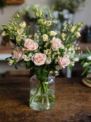 bouquet of flowers in glass vase on wooden table