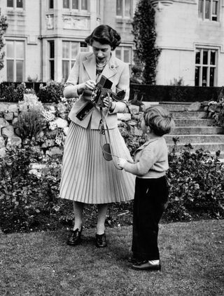 Queen Elizabeth and her son Charles playing with a camera in the grounds of Balmoral Castle, Scotland.
