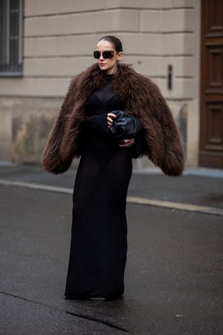 woman wearing brown faux fur coat and all-black outfit