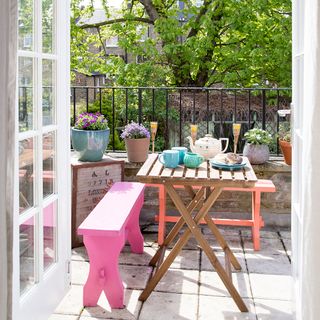 balcony garden with wooden table and potted plants